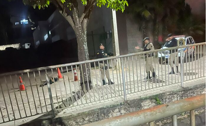 Policiais militares preservam a área isolada após um homicídio registrado nas proximidades do Torneio Leiteiro, em Santa Bárbara (MG), durante a noite.