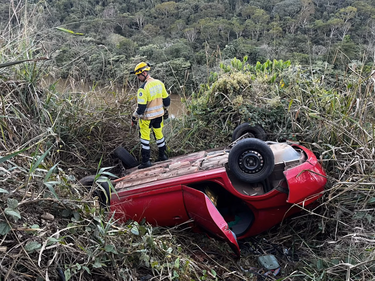 Carro capotado em ribanceira na Estrada do Jacuí durante atendimento do Corpo de Bombeiros em João Monlevade