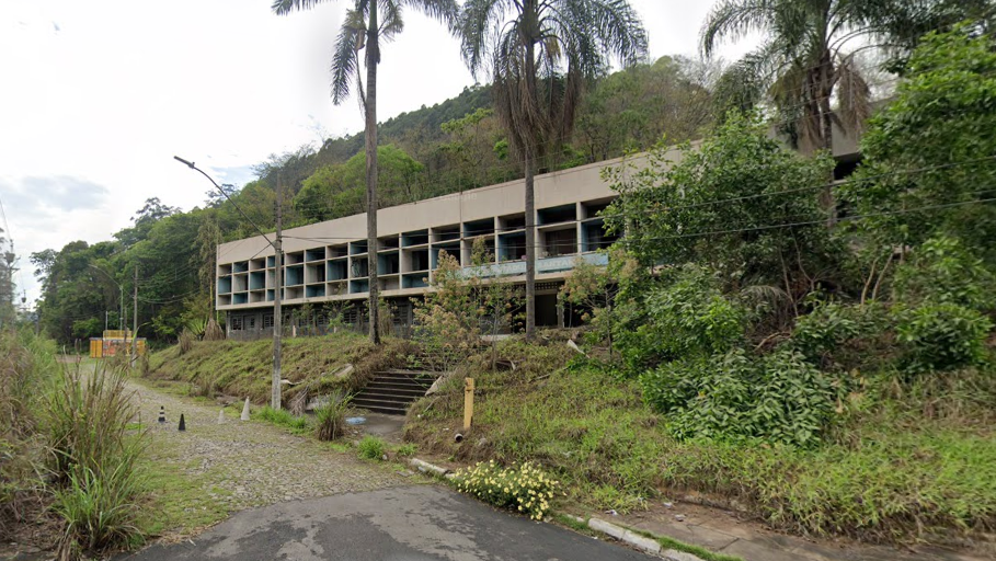 Fachada da antiga Escola Estadual Santana, em João Monlevade, fechada e com sinais de deterioração. O imóvel está desativado desde 2016, foi tombado pelo Município em 2022 e aguarda definição do Governo de Minas sobre sua recuperação.